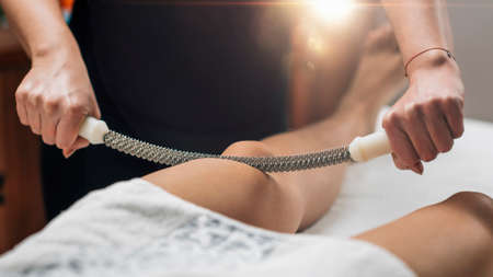 Anti-cellulite thigh massage with a metal rolling pinの写真素材