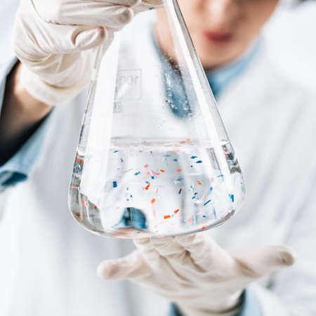 Microplastics laboratory analysis. Scientist observing microplastics or tiny plastic particles in a...
