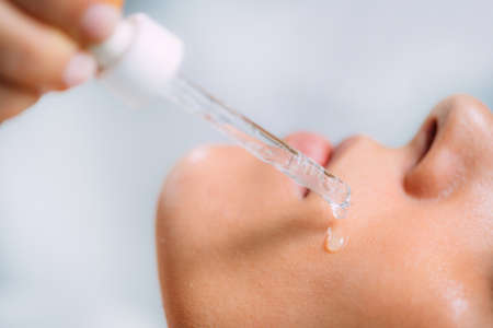 Cosmetician Applying Hyaluronic Acid Serum on Womanâs Faceの写真素材