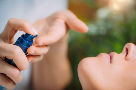 Retinol Treatment. Cosmetician Applying Retinol Serum on Womanâ€™s Face