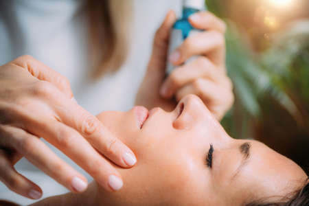 Cosmetician Applying Hyaluronic Acid Serum on Womanâs Faceの写真素材