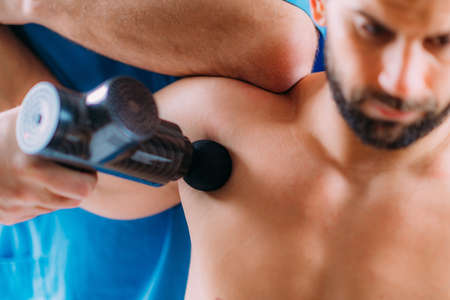 Therapist Treating Chest Injury on Athlete with Massage Gun