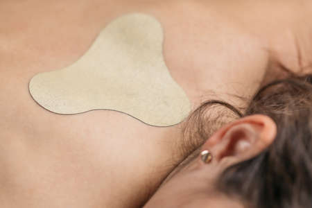 Herbal Plaster Back Treatment. Unrecognizable woman lying with herbal plaster applied on the back.の写真素材