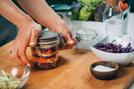 Vegetable fermentation. Woman holding jar with fermented vegetables.の写真素材