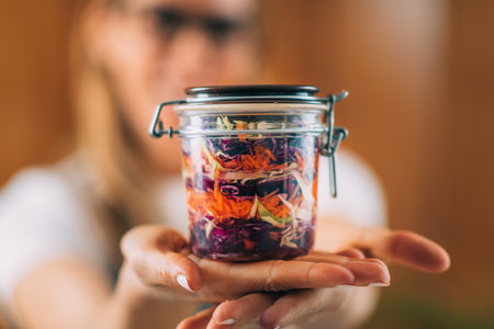 Vegetable fermentation. Woman holding jar with fermented vegetables.の写真素材