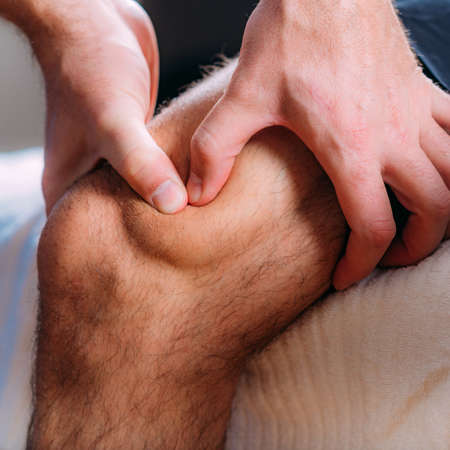 Knee sports massage physical therapy. Physiotherapist massaging injured knee. Sports injury treatment.の写真素材