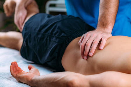 Discus Hernia manual massage treatment. Physical therapist massaging lower back.の写真素材