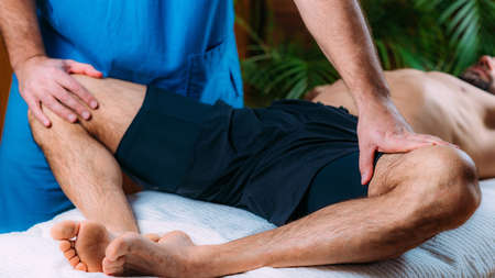 Discus Hernia manual massage treatment. Physical therapist massaging lower back.