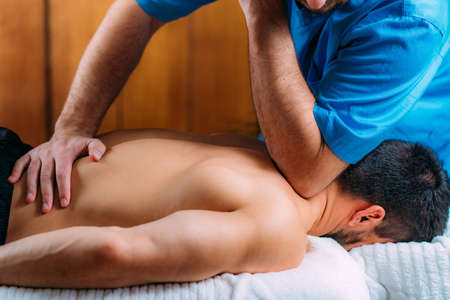Shoulder blade or scapula pone physical therapy. Physiotherapist massaging patientâ€™s...