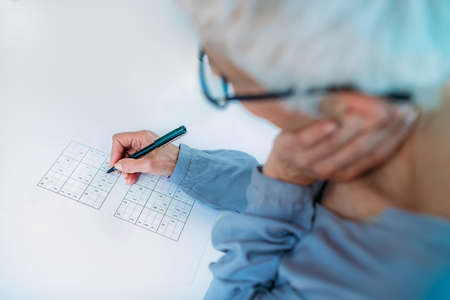 Cognitive training. Senior woman solving sudoku puzzles.の写真素材
