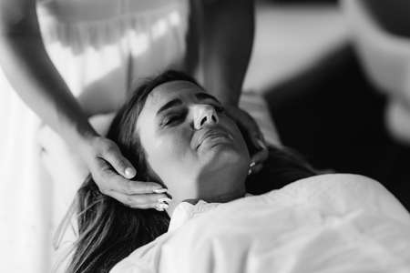 Reiki Therapist Transferring Energy. Peaceful Woman Lying with Her Eyes Closed.の写真素材
