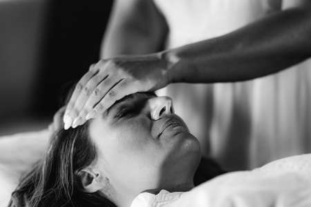 Reiki Healing. Woman Lying with Her Eyes Closed, Having Treatment.の写真素材