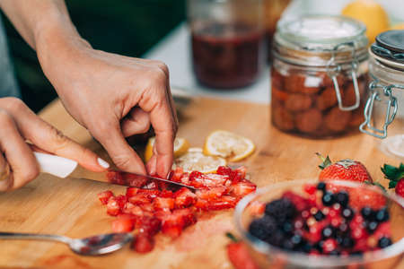 Cutting strawberries in the kitchen. Fruit fermentation.の写真素材