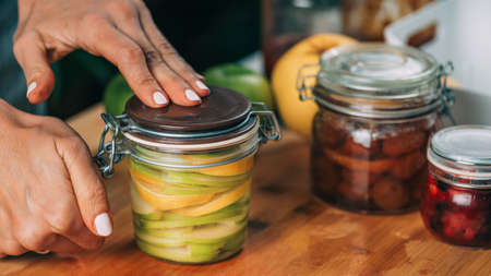 Woman holding jars with fermented fruits.の写真素材