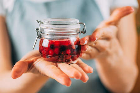 Fruit fermentation. Woman holding jar with fermented fruit.の写真素材