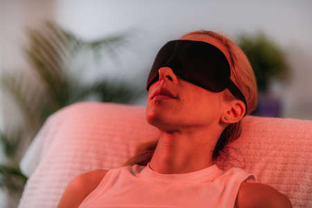 Color light therapy. Female face under the red light
