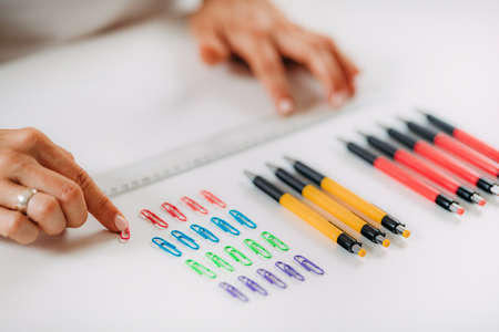 Woman with OCD â Obsessive compulsive disorder concept. Placing paperclips in a straight line.の写真素材