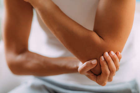 Elbow pain. Woman with painful elbow.の写真素材
