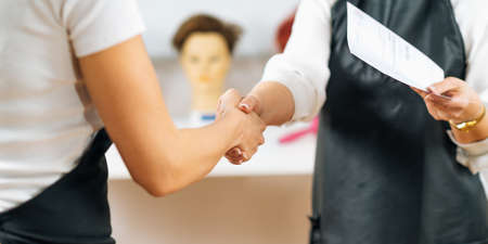 Handshake - hairstyling educator and female student at the end of hairstylist trainingの写真素材