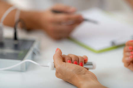 Quantum medicine body, analysis. Woman holding an electrode during a quantum analysis session