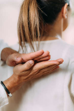 Woman enjoying shiatsu back massage, sitting on the shiatsu massage mat.の写真素材