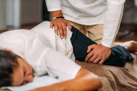 Therapist stretching womanâs leg. Shiatsu massage.の写真素材