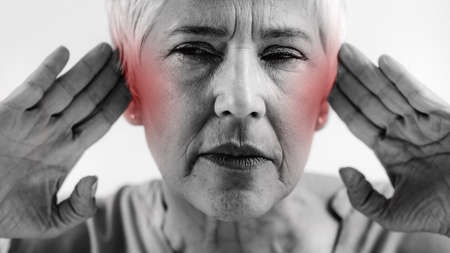 Tinnitus. Senior woman suffering from tinnitus.の写真素材
