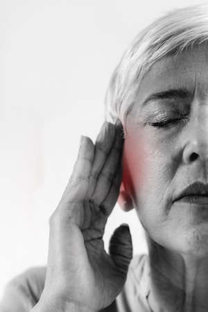 Tinnitus. Senior woman suffering from tinnitus.の写真素材