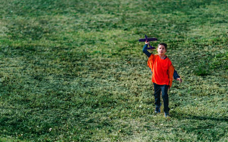 Boy playing with airplane glider toy in the park.の写真素材