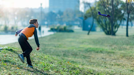 Boy playing with airplane glider toy in the park.の写真素材