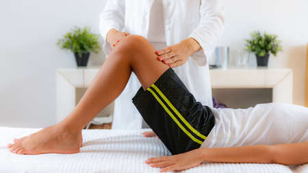 Pediatric doctor doing medical exam with boy on bed.の写真素材