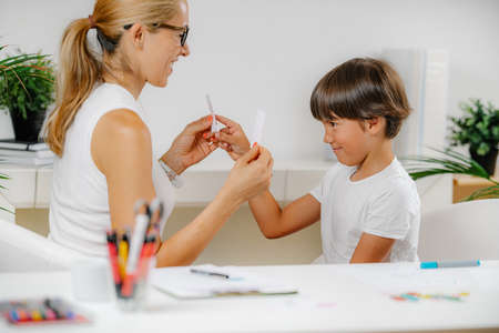 Boy doing a school assessment test. Psychologist holding shapes, and boy recognizing them.の写真素材