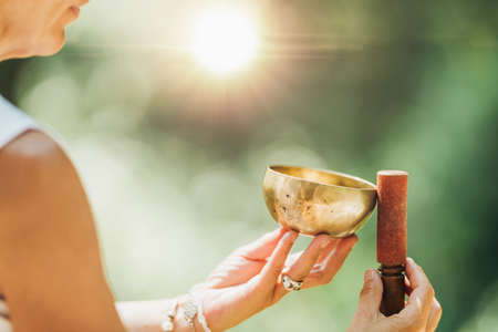 Tibetan singing bowl in sound healer hands outdoorsの写真素材