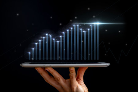 Digital Marketing Fueling Sales Growth. Conceptual image, hand holding a tablet with virtual graphs...