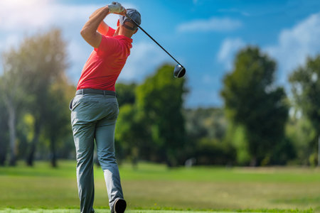 Pro golfer in a golf swing, using a driver golf club, rear viewの写真素材