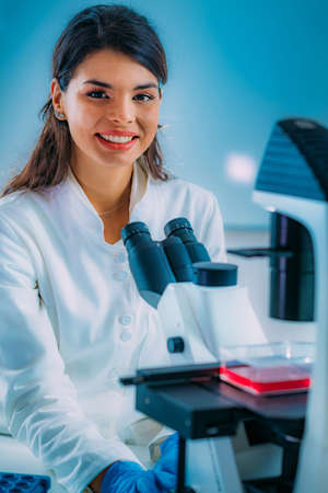 Biology Student Researcher Looking Through the Microscopeの写真素材