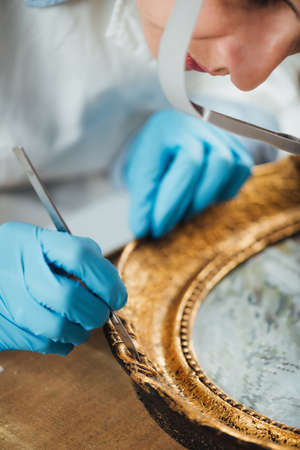 Restoring an antique gold picture frameの写真素材