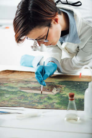 Restoring old oil painting, conservator removing varnish from an oil paintingの写真素材