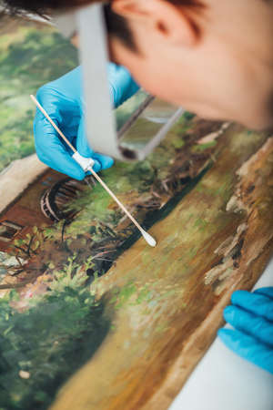 Cleaning and restoration of an old oil painting, surface cleaning processの写真素材