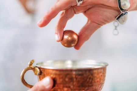 Reintegration positive emotion concept. Hands of a spiritual teacher, holding a copper ball,...