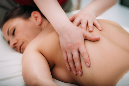Back massage in a massage salon, woman having a relaxing back massage.の写真素材