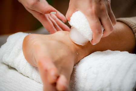 Wrist Injury Ice Massage. Hands of a therapist placing ice directly onto a painful wrist to relieve pain, reduce inflammation and swelling and promote healing.の写真素材