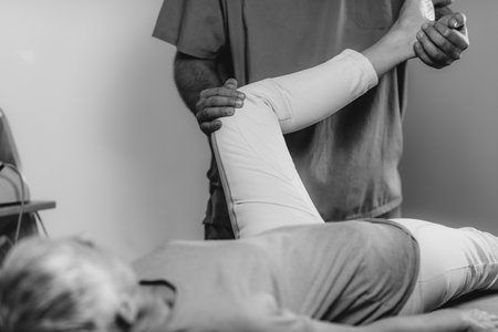 Physical Therapist Working with Leg. Senior Womanの写真素材
