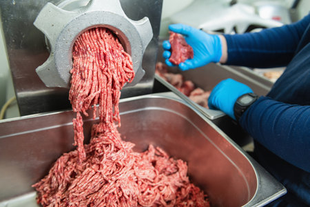 Minced beef meat in a professional grinding machine in a large restaurant close upの写真素材