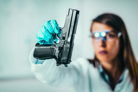 Forensic Science in Lab. Forensic Scientist examining gun with evidencesの写真素材