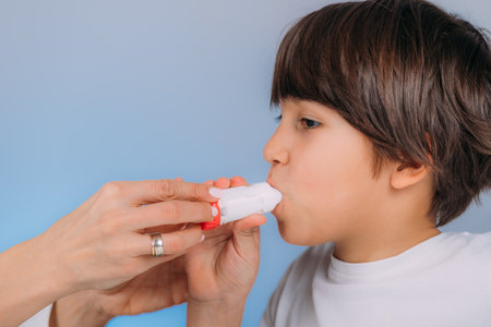 Pediatric pulmonologist helping little boy with aero inhaler. Pulmonologist, medical doctor who specializes in the diagnosis and treatment of diseases and disorders of respiratory system, lungs, bronchial tubes, trachea and structures involving in breathing.の写真素材