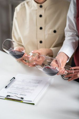 Red wine tasting. Participants compare the colors of different red wines in a wine tasting event, learning to identify the wine's age, grape varietal, and other key details based on hue.の写真素材