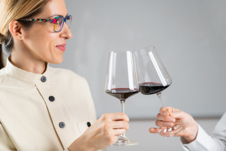 Toasting with red wine in a wine tasting event: a female guest toasts with a glass of red wine.の写真素材