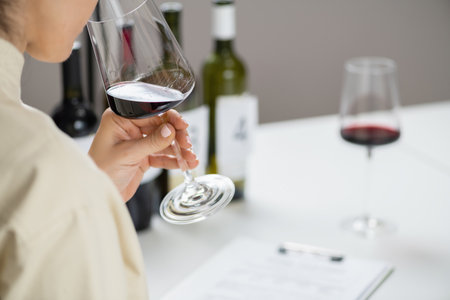Wine tasting. A woman enjoys a red wine tasting, savoring the wine's flavors and aromas.の写真素材