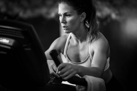 Female athlete exercising on a treadmill, black and white